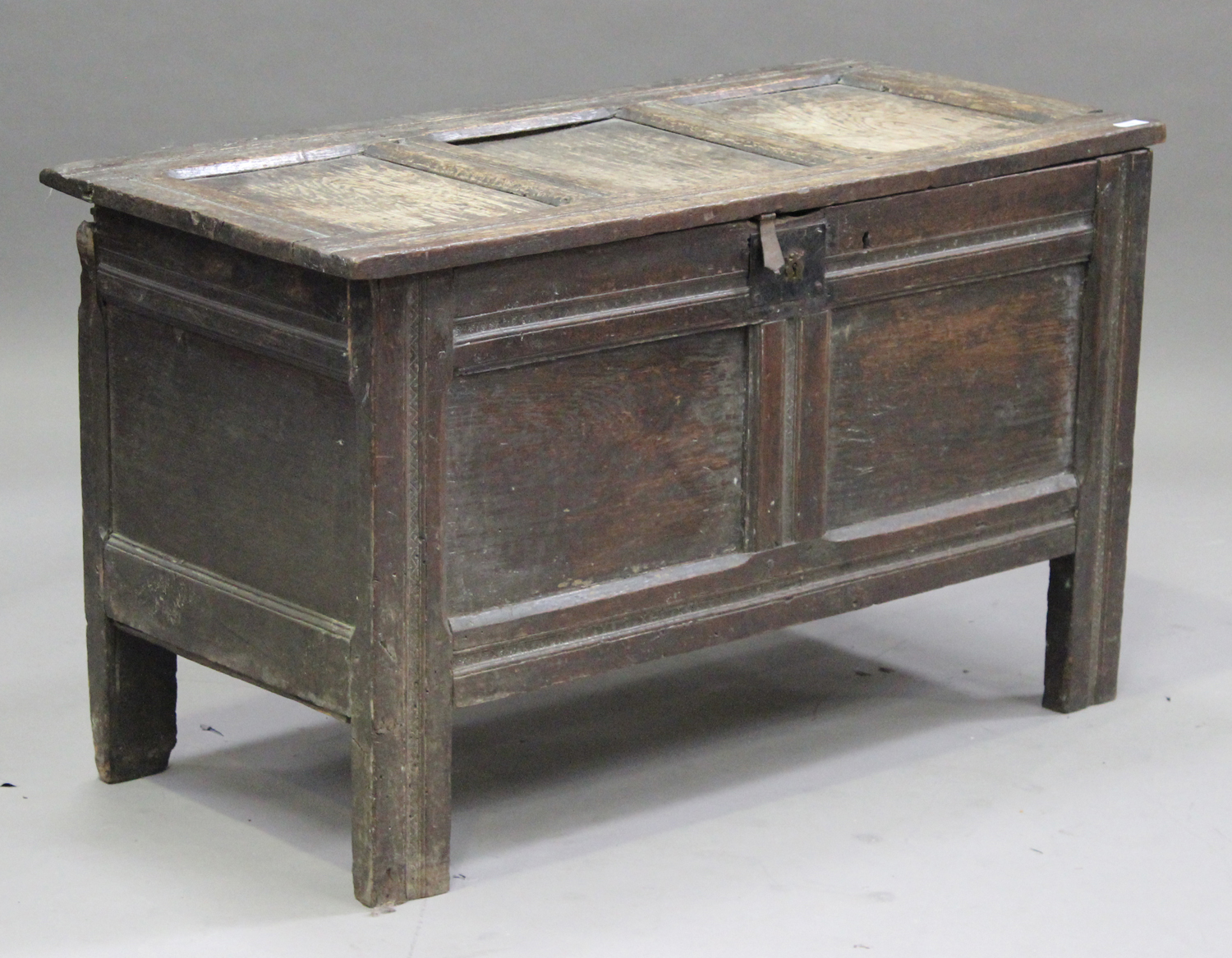 An 18th century oak panelled coffer, the hinged lid revealing a candlebox, on stile supports, height