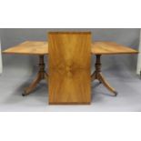 A George III style satin walnut 'D' end twin pedestal dining table with single additional leaf, on