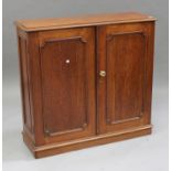 A Victorian oak cabinet, fitted with shelves enclosed by two panelled doors, on a plinth base,