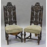 A pair of 19th century French oak side chairs, profusely carved with leaf scrolls, the overstuffed