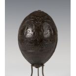 A 19th century carved coconut bugbear powder flask, one end typically worked with a mask with