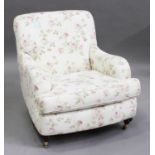 A modern Howard style armchair, upholstered in a floral cotton, on turned legs and castors, height