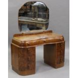 An Art Deco walnut dressing table, the mirror back above a serpentine fronted base, fitted with
