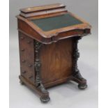 A Victorian walnut Davenport with inlaid decoration, the hinged writing surface above four