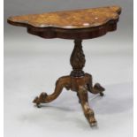 A Victorian walnut fold-over card table, the shaped top raised on a carved baluster column and