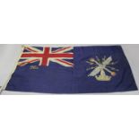 A British linen ensign with Union Jack to one corner and painted with a crest, 96cm x 185cm.Buyer’