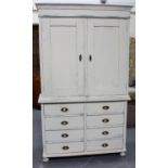 A 19th century white painted press cupboard, the base fitted with eight short drawers, on bun