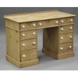 A Victorian stripped pine twin pedestal desk, fitted with an arrangement of nine drawers, on