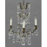 A mid-20th century cast gilt brass and glass mounted four light chandelier, hung with ovoid glass
