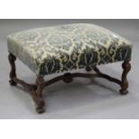 A late 19th/early 20th century French walnut footstool, the overstuffed seat raised on carved scroll