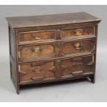An early 18th century oak chest of two short and two long drawers with applied geometric