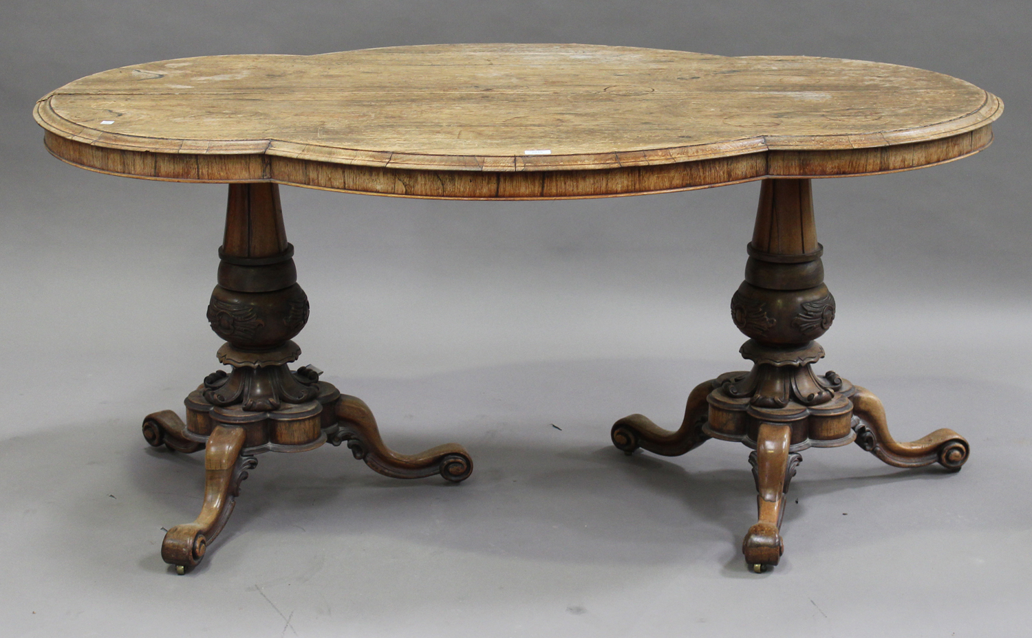 An early Victorian rosewood centre table, the shaped top raised on two turned and carved baluster