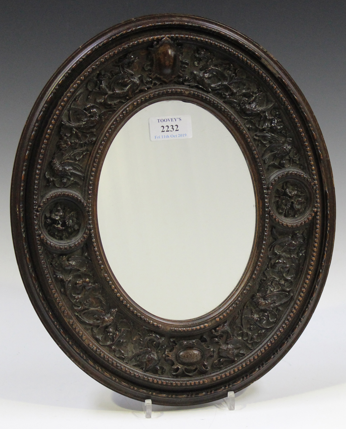 A 19th century Italian Baroque Revival carved wooden oval wall mirror, the wide frame finely