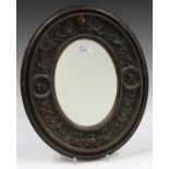 A 19th century Italian Baroque Revival carved wooden oval wall mirror, the wide frame finely