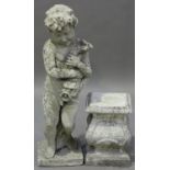 A 20th century cast composition stone garden fountain figure of a putto holding a large fish, raised