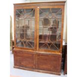 A 19th century mahogany bookcase cabinet, the moulded pediment above a pair of astragal glazed