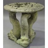 A 20th century cast composition stone circular garden table, the top raised on three Regency dolphin
