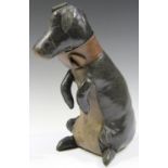 A mid-20th century stained black and brown leather novelty model of a seated begging dog, fitted