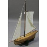 An early 20th century wooden pond yacht with cloth sails, length 107cm.Buyer’s Premium 29.4% (