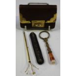 A 9ct gold mounted brown leather rectangular purse, London 1922, a gold slide-action swizzle stick