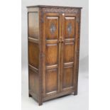 A mid-20th century Jacobean Revival oak hall cupboard, the carved lunette frieze above a pair of