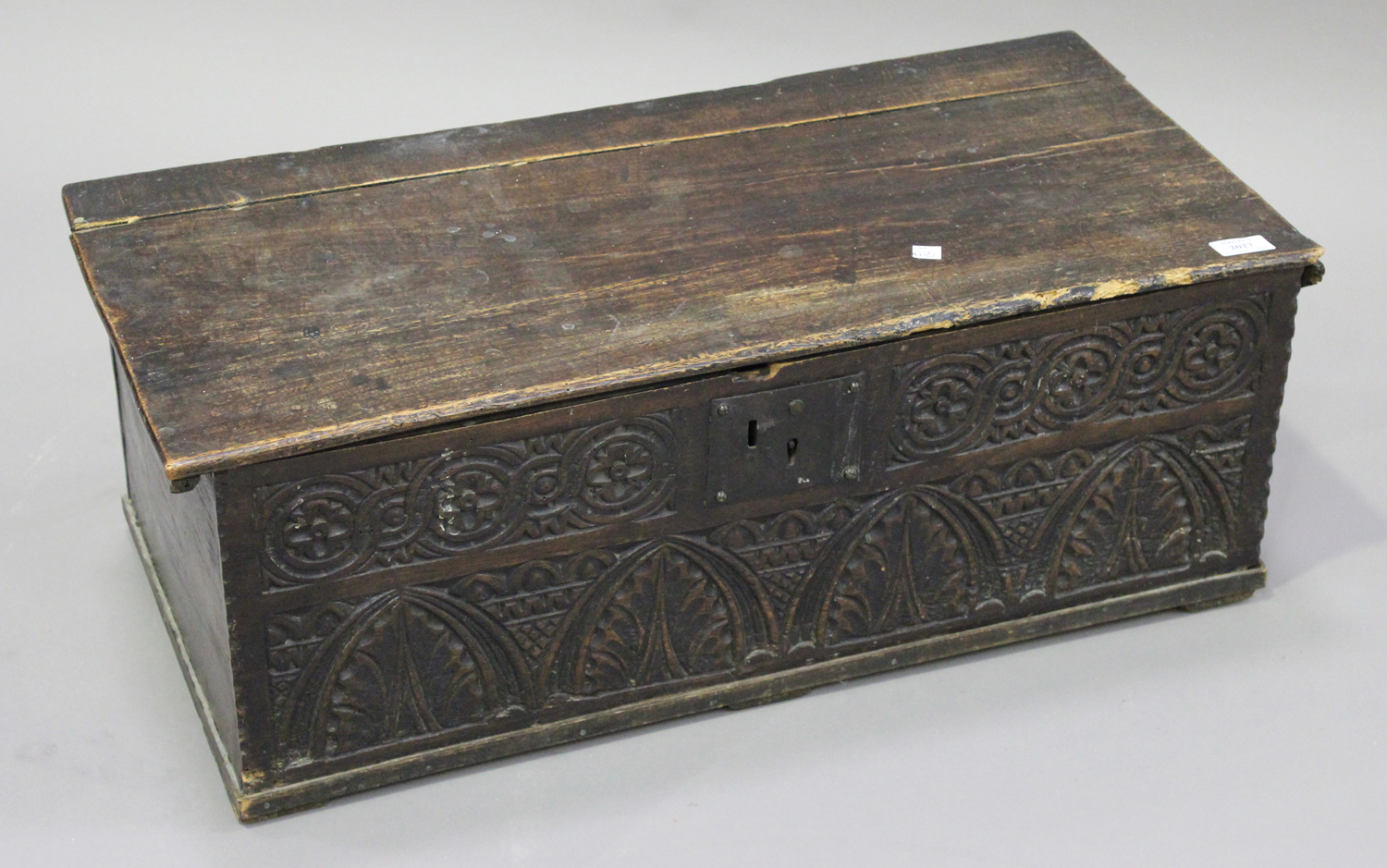 A 17th century oak bible box, the hinged lid above a carved front, height 28cm, width 76cm.Buyer’s