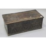 A 17th century oak bible box, the hinged lid above a carved front, height 28cm, width 76cm.Buyer’s
