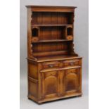 A late 20th century reproduction oak dresser, the shelf back above two drawers and a pair of panel