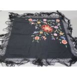 An early 20th century black silk shawl, embroidered with flowers and butterflies, 116cm x 108cm,