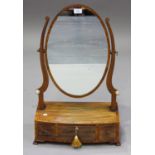 A George IV mahogany oval swing frame toilet mirror, the bowfront base fitted with three drawers, on