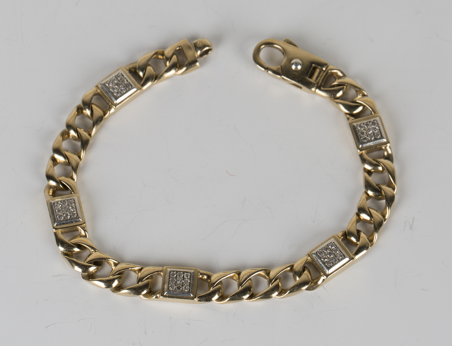 A 9ct gold and diamond bracelet in a faceted curblink design, spaced with five diamond set nine