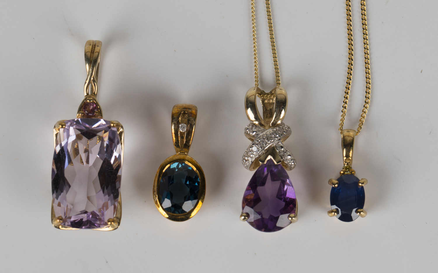 A 9ct gold pendant, claw set with a pear shaped amethyst with a diamond set surmount, length 2cm,