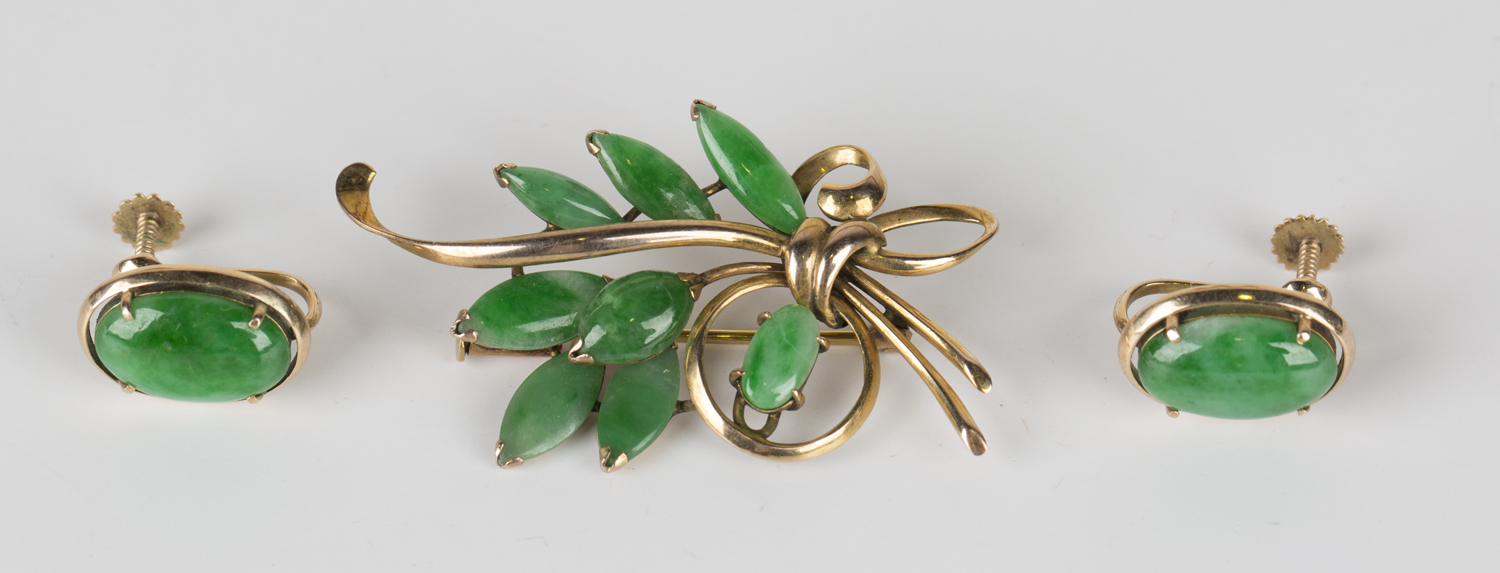 A gold and jade brooch, designed as a spray, mounted with marquise and oval jades, detailed '14K',