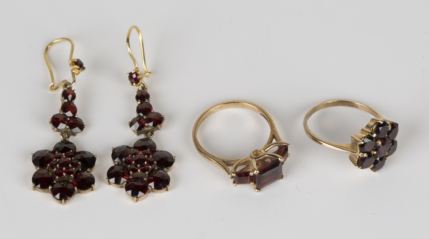 A 9ct gold and garnet set three stone ring, mounted with square cut garnets, ring size approx N, a