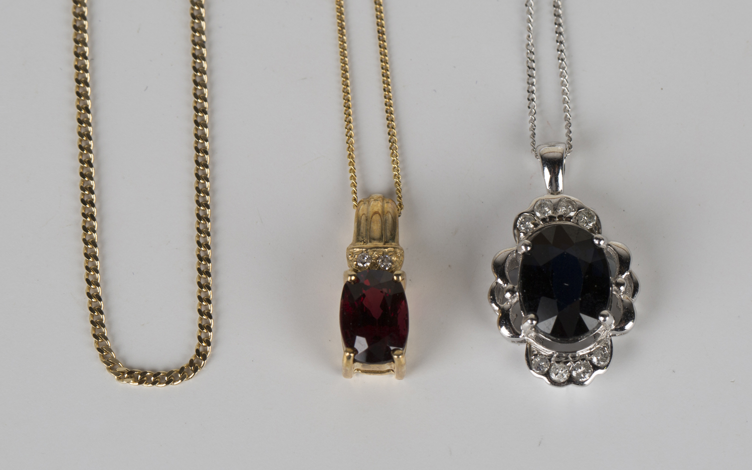 A 9ct gold, garnet and diamond pendant, length 1.7cm, with a 9ct gold neckchain, length 44.5cm, a