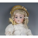 A German bisque head doll with blonde wig, sleeping blue eyes, painted eyebrows and lashes, open