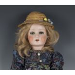 A Schoenau & Hoffmeister bisque head doll, impressed '914 10', with later blonde wig, sleeping
