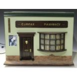 A late 20th century doll's 'Carfax Pharmacy', the opening front with a door and bay window,