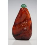 A Chinese amber snuff bottle, probably late Qing dynasty, carved in low relief with a fish and toad,