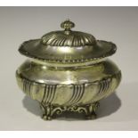 An Edwardian silver oval tea caddy, the spiral reeded domed hinged lid and reeded finial above a