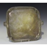 A George V silver salver of square form with rounded corners, the cast gadrooned rim decorated