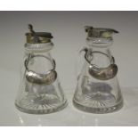 A pair of George V silver mounted clear cut glass conical whisky tots, each with hinged lid,