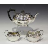 A George V silver three-piece tea set of oval form with gadrooned rims, comprising teapot, two-
