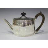 A George III silver oval teapot and cover with hinged lid, turned wood finial and scroll handle, the