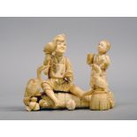 A Japanese carved ivory figure group of a fisherman seated on a rice bale together with a child