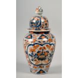 A 19c Imari vase of baluster form with a domed cover, decorated with floral panels in red and blue