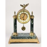 A late 19c French mantel clock, the brass drum of the movement supported on two variegated marble
