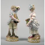 A pair of 19c Meissen figures of children with grapes on circular gilt decorated bases, crossed