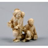 A Japanese carved ivory figure group of a family of travellers, she carrying pots and a baby, he