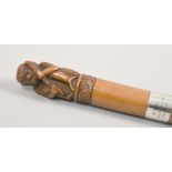 A walking stick with silver band, the handle carved as a seated monkey, 38in l.